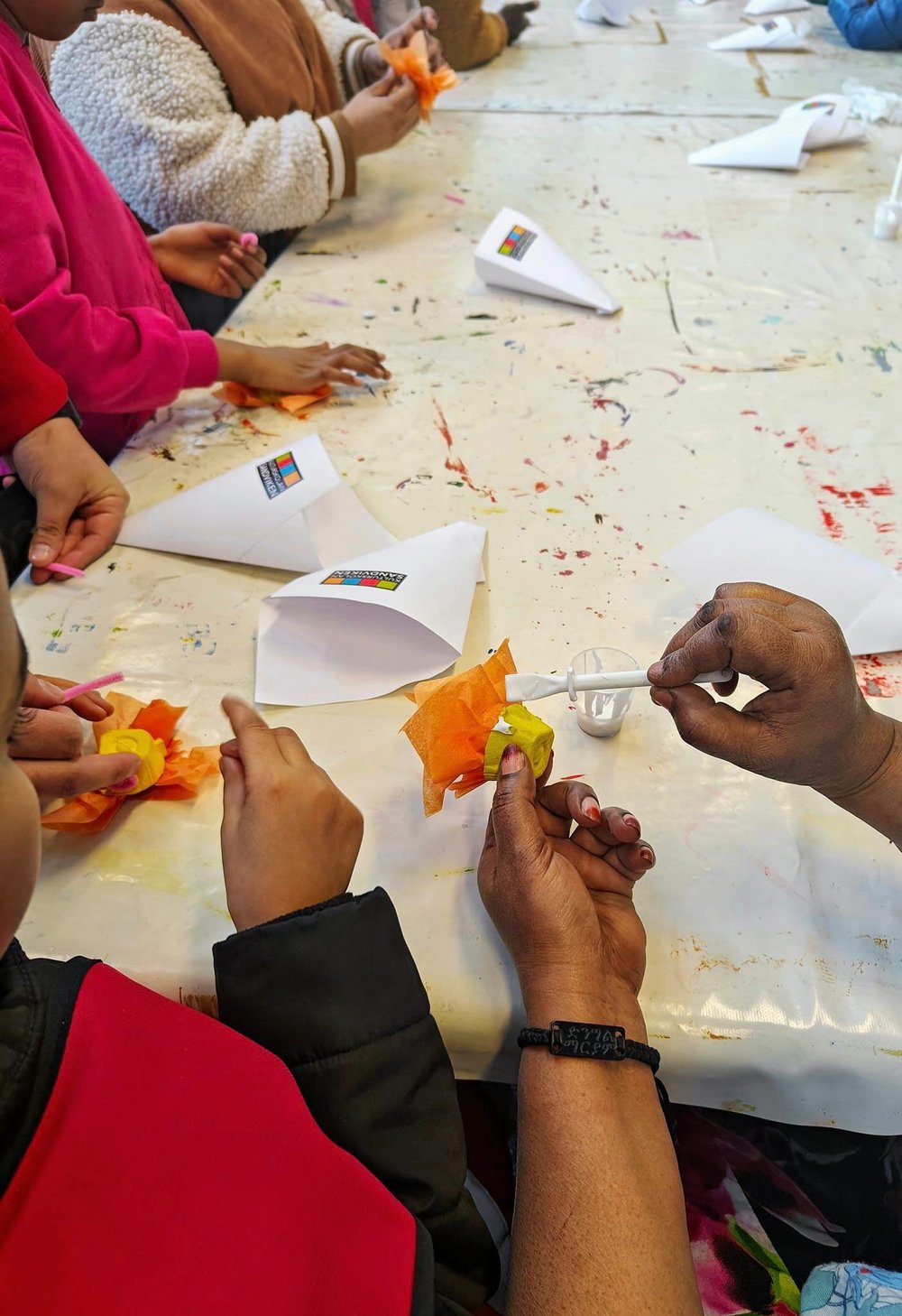 Barnhänder vid ett bord som pysslar med höstlöv