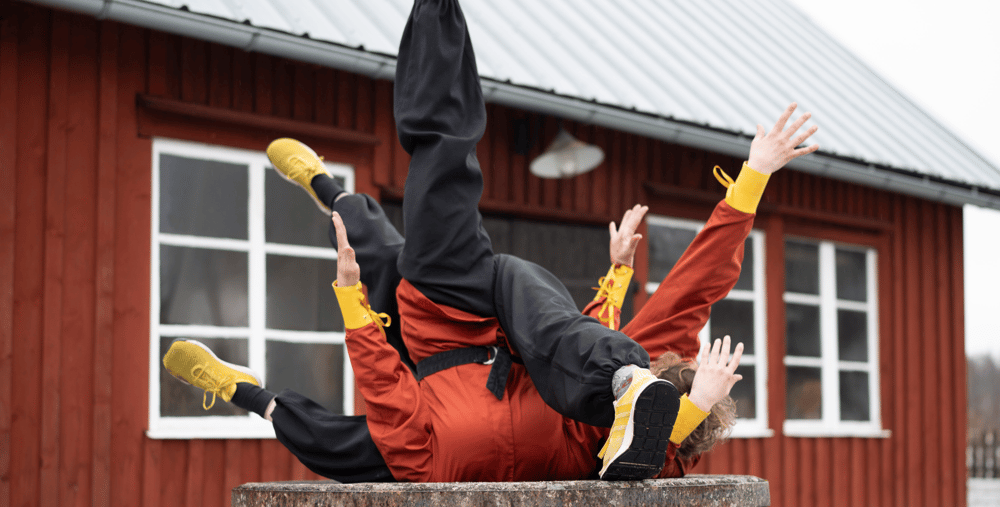 personer som ligger på en bänk framför en röd byggnad.