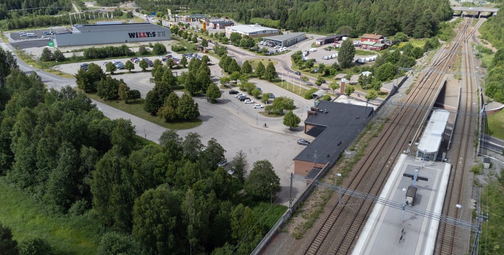 En flygbild av en tågstation och omgivande träd.
