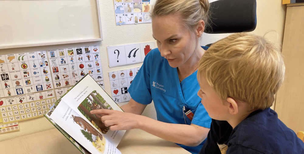 En kvinna som läser en bok för en liten pojke.