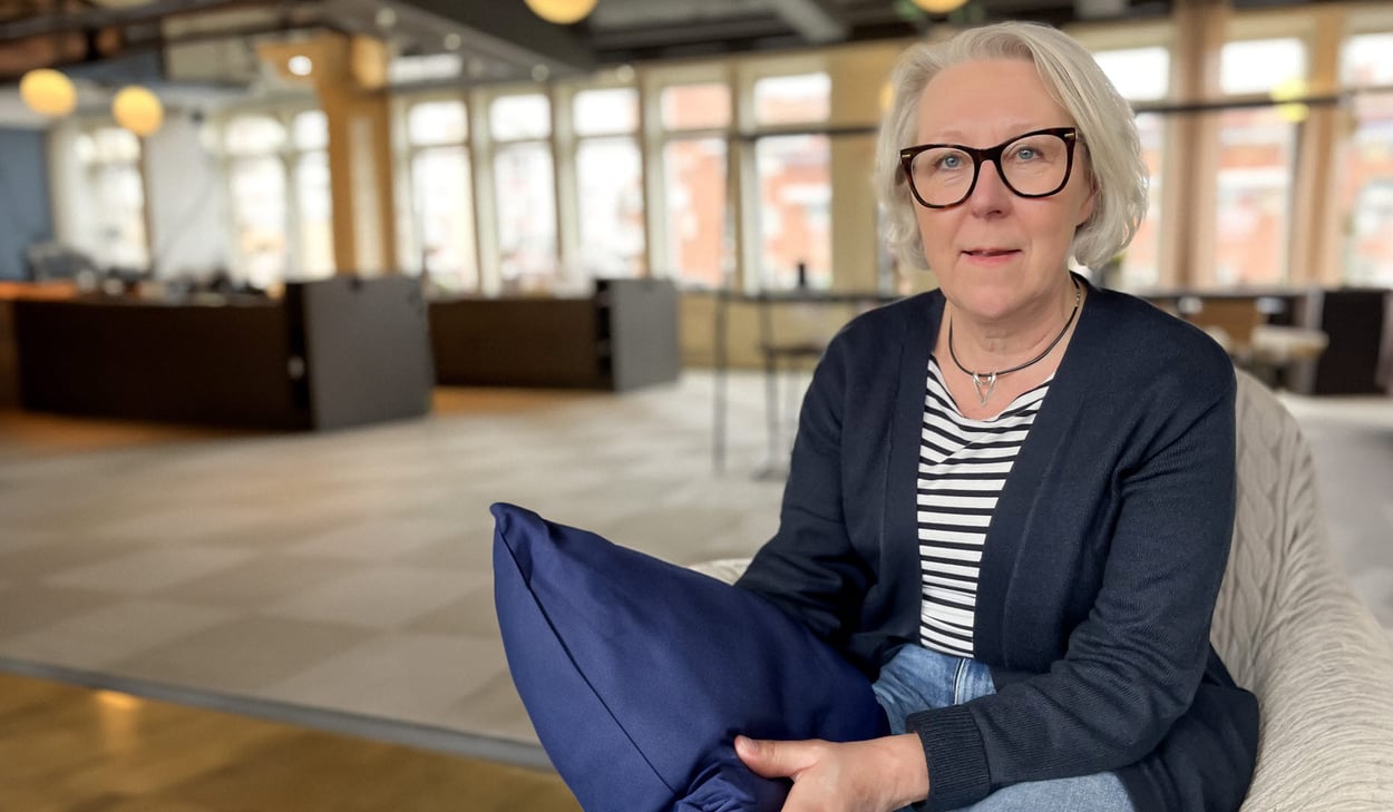 Kvinna i halvfigur med sovkudde i handen