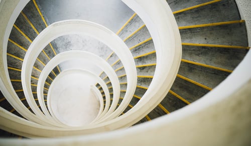En spiraltrappa med gult och vitt räcke.