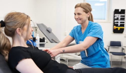 En kvinna får sin fot undersökt av en läkare.