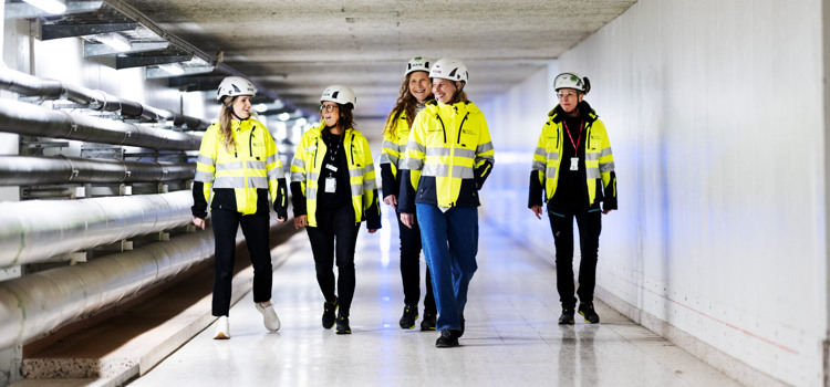 En grupp människor som går längs en lång korridor.