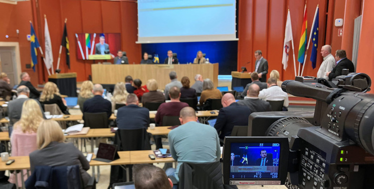 En grupp människor som sitter framför en kamera.
