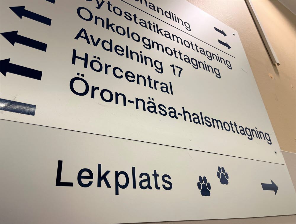 Skylt från sjukhuset. Riktningspilar för bland annat onkolgmottagning och lekplats.