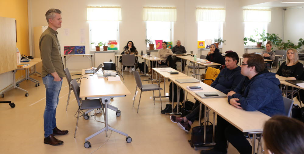Lärare står framför kursdeltagare som sitter i klassrum