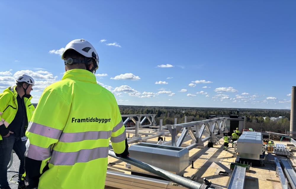 Byggprojektledaren inspekterar bygget av den nya helikopterplattan på taket av hus 60 på Gävle sjukhus. I bakgrunden syns Magnus Busk, programchef för Framtidsbygget.