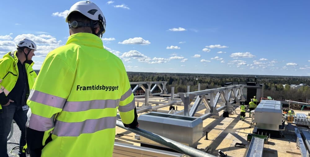 Byggprojektledaren inspekterar bygget av den nya helikopterplattan på taket av hus 60 på Gävle sjukhus. I bakgrunden syns Magnus Busk, programchef för Framtidsbygget. 