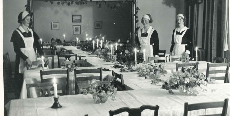 Julbord i sköterskornas dåvarande matsal Bollnäs lasarett. Dukat bord. Tre sköterskor ses stående intill bordet.