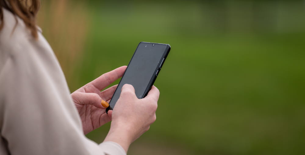 Sandra Persson använder mobiltelefon.