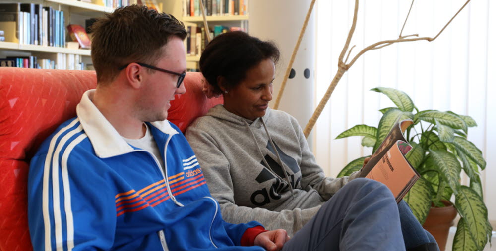 Två kursdeltagare som sitter och läser en tidning